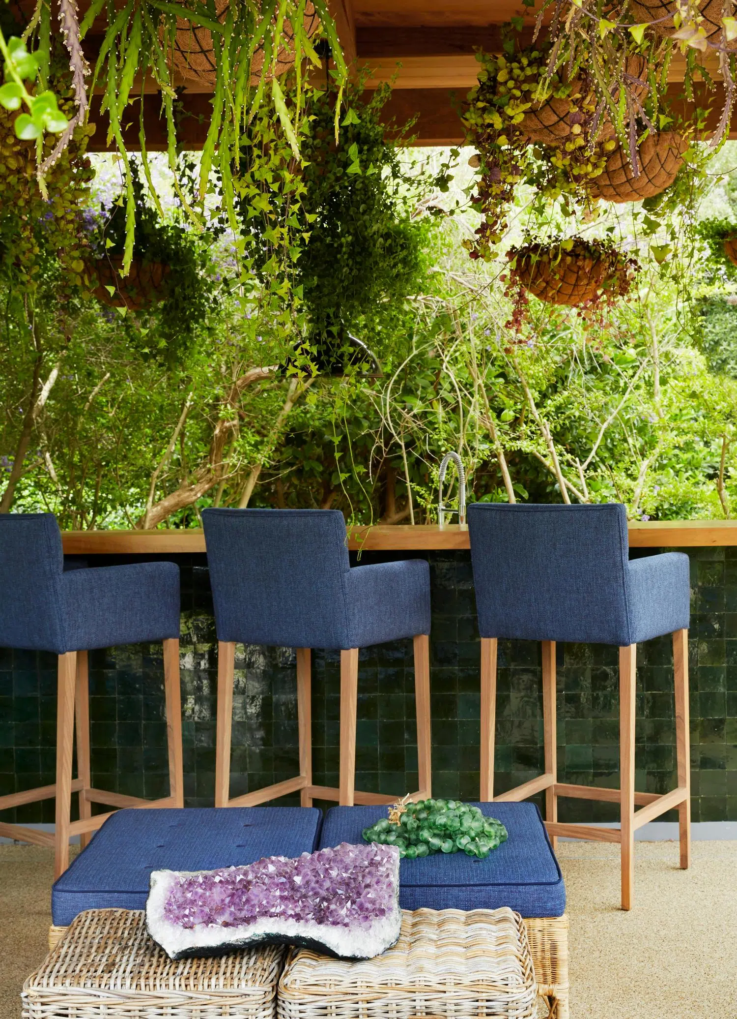 Three bar stools at an outdoor, wooden bar.