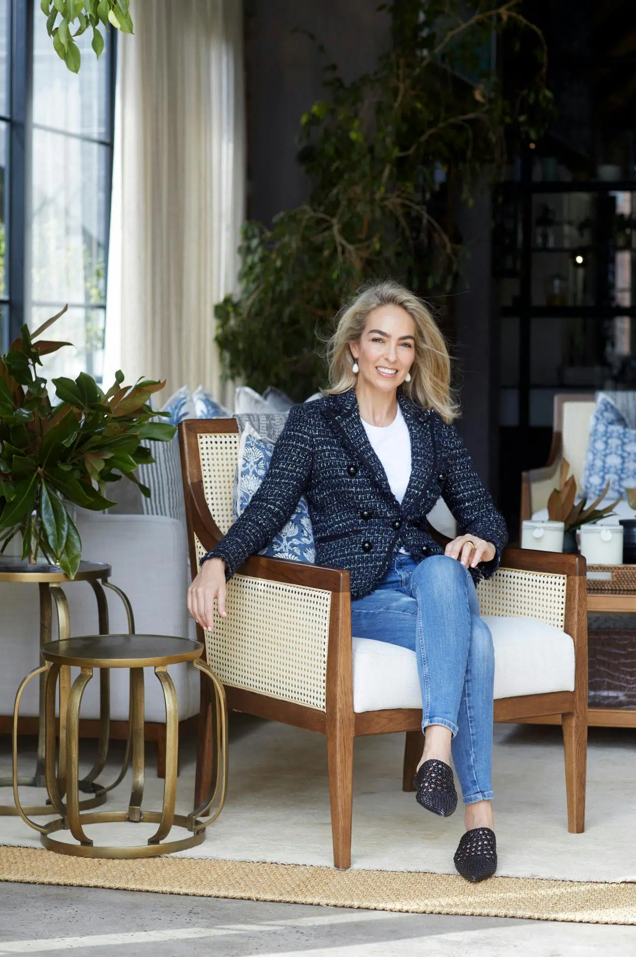 Simone Katherine sitting on a wooden chair alongside two side tables.