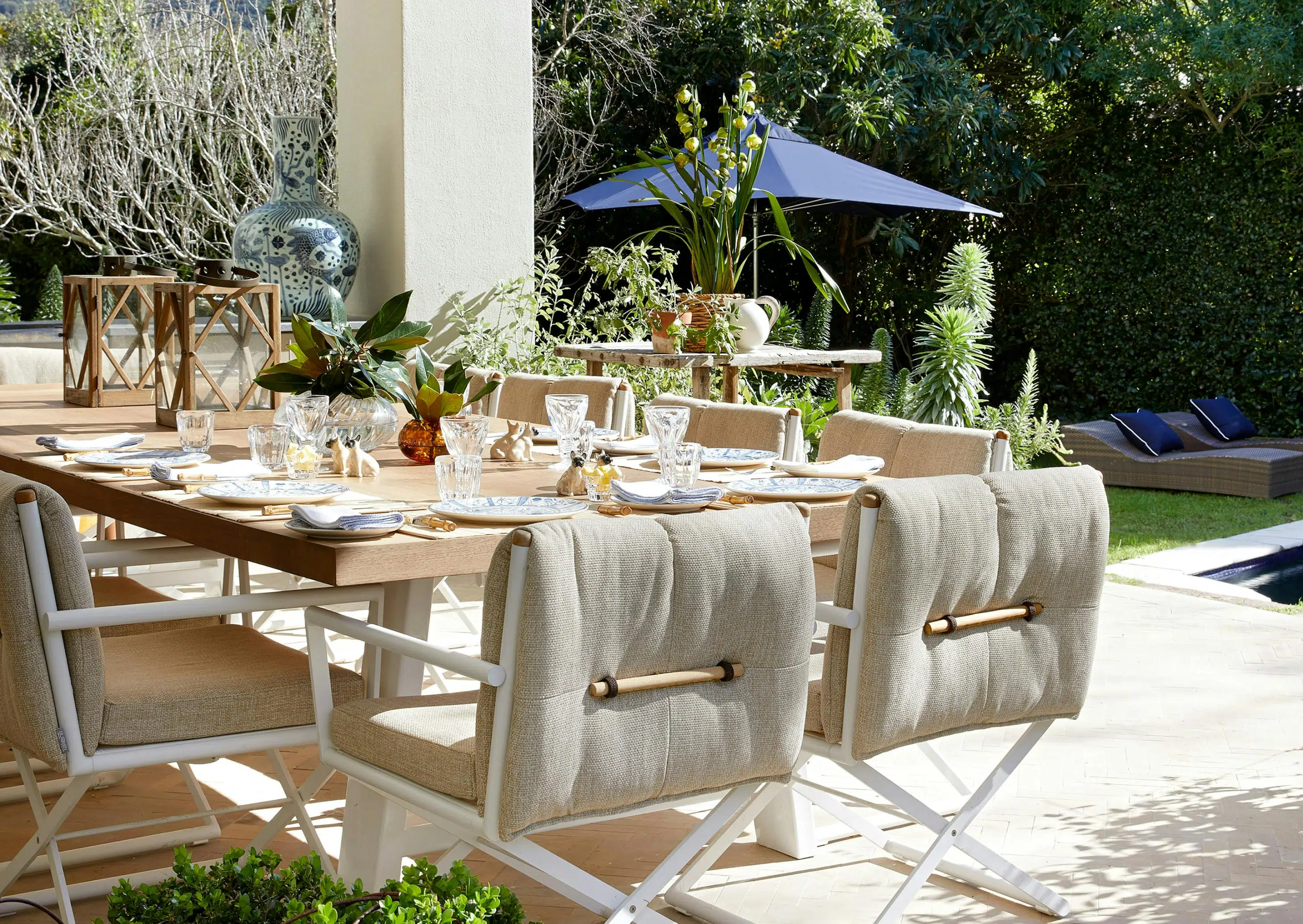 An outdoor dining area with views of a mountain in the background and a wooden dining table with modern chairs in the foreground.